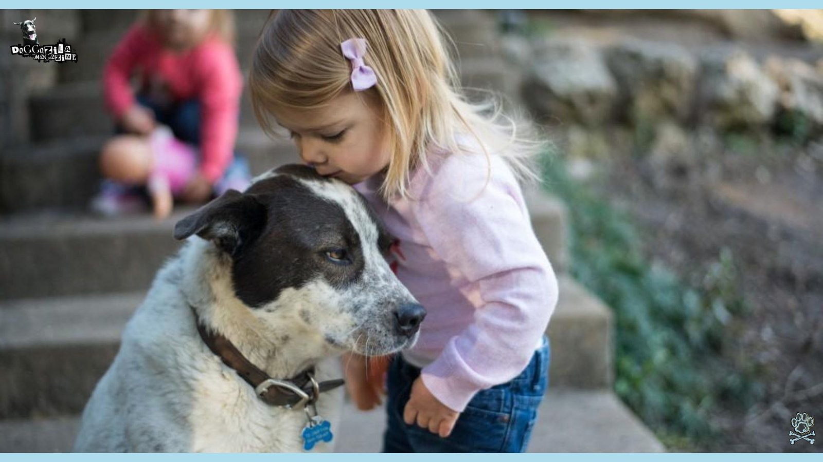 little girl kissing her dog on the head